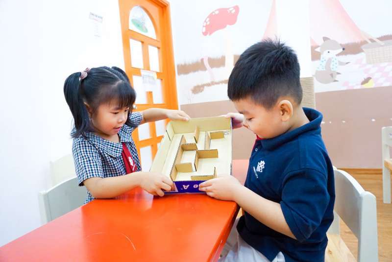 Mỗi nhóm hào hứng chơi trò ai lăn bóng qua mê cung nhanh hơn