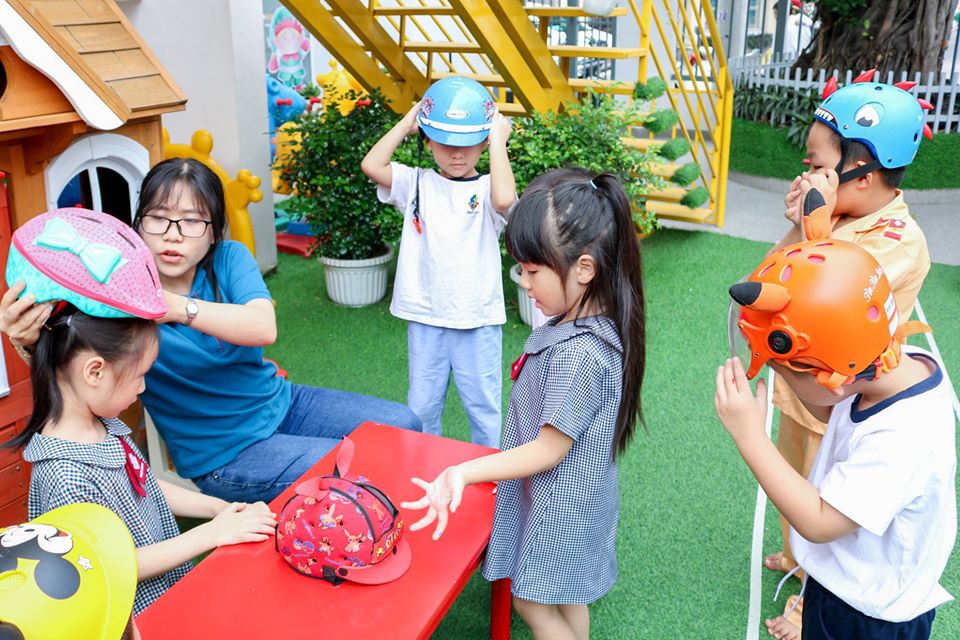 Bé học cách đội nón bảo hiểm