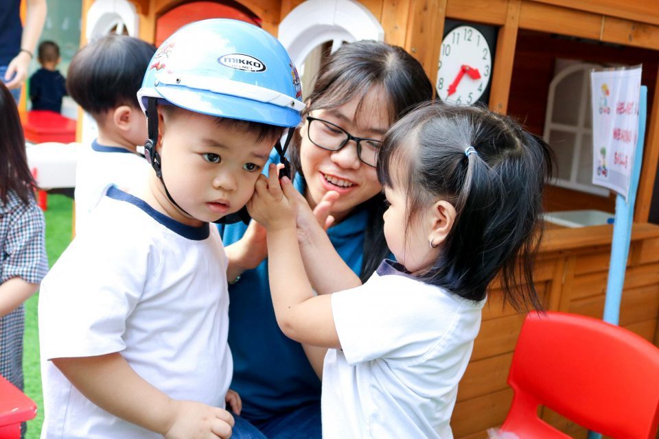 Bé học cách đội nón bảo hiểm