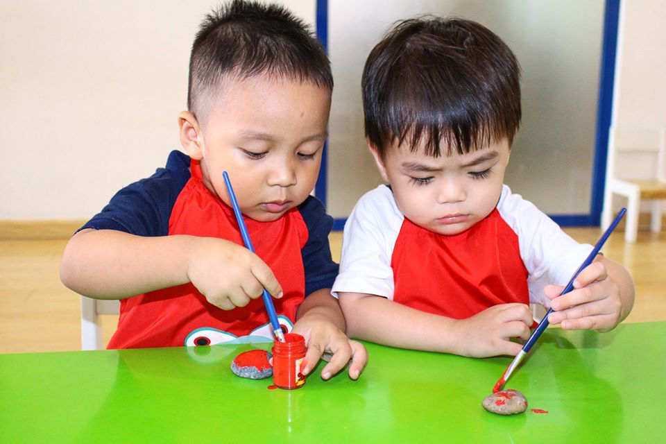 Bé vẽ trên đá