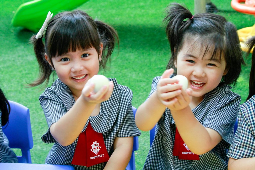 Các cô bật diêm đốt mảnh giấy cho vào trong bình và nhẹ nhàng đặt quả trứng lên